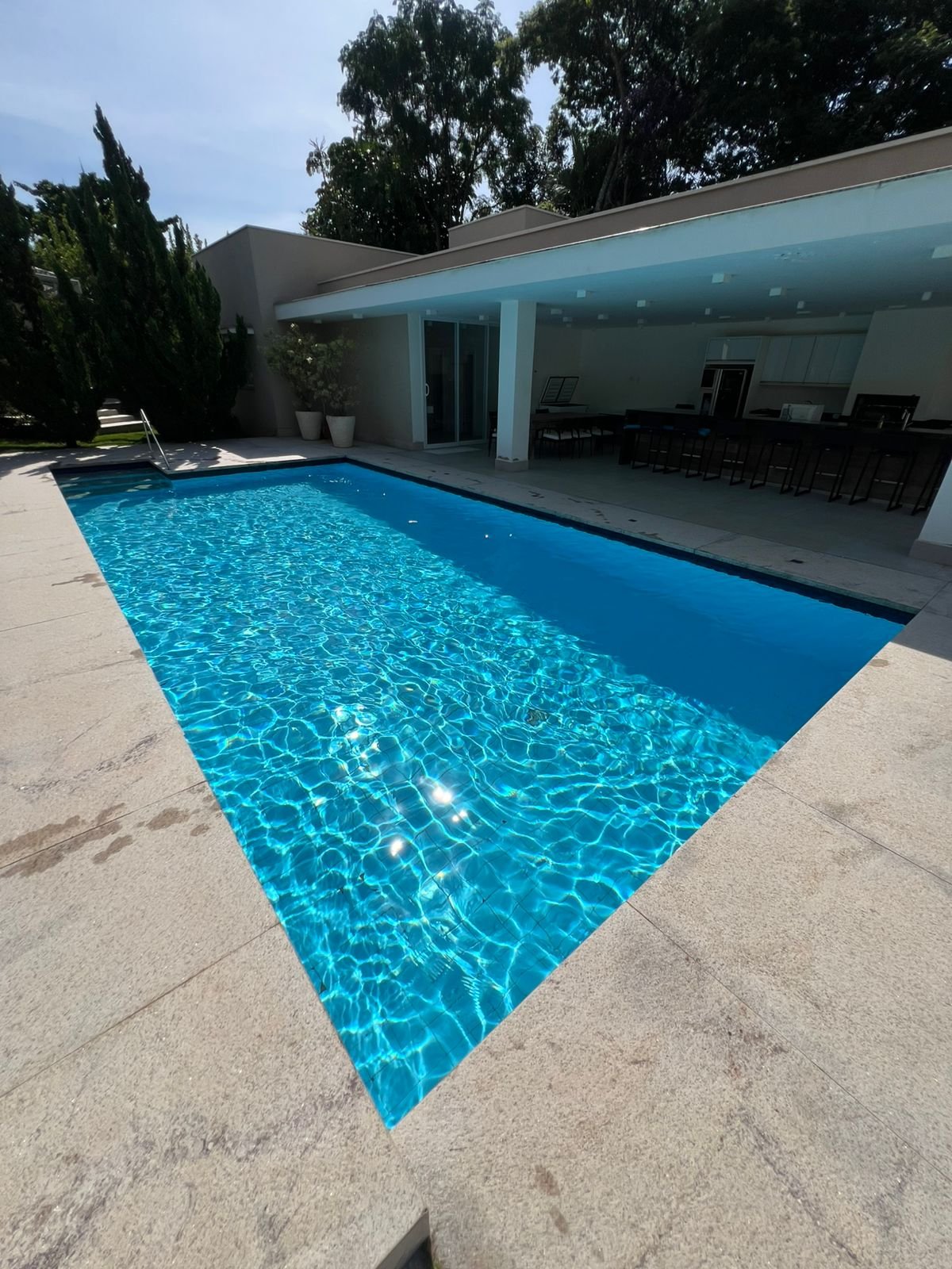 Área de lazer com piscina limpa e equilibrada